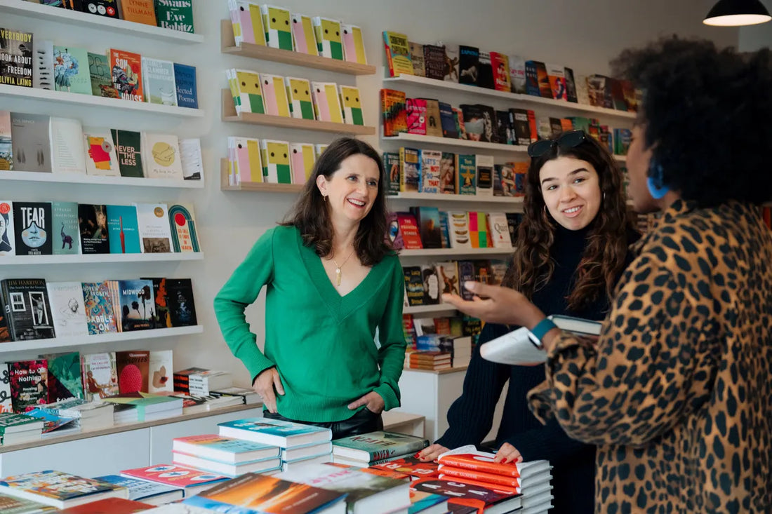 Martha Sharpe, left, owner of Flying Books, speaks with employee Ally Shap, centre, and customer Hadiya Roderique at the store’s location on College Street in Toronto, on Oct. 28